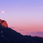 Sunset lit rockface with moon in the background