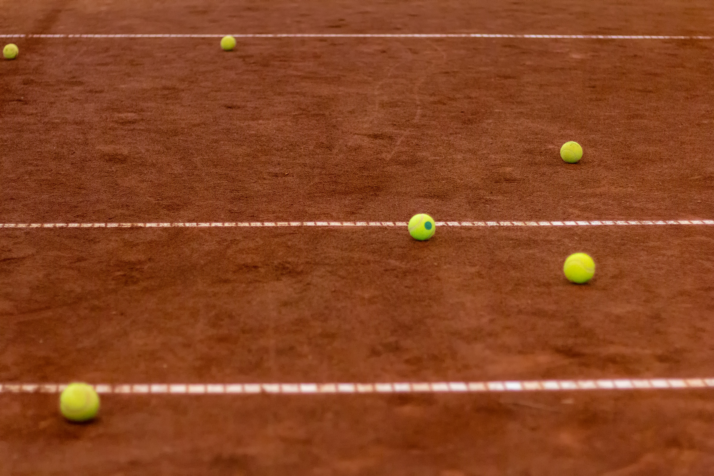 Tennis balls scattered on court