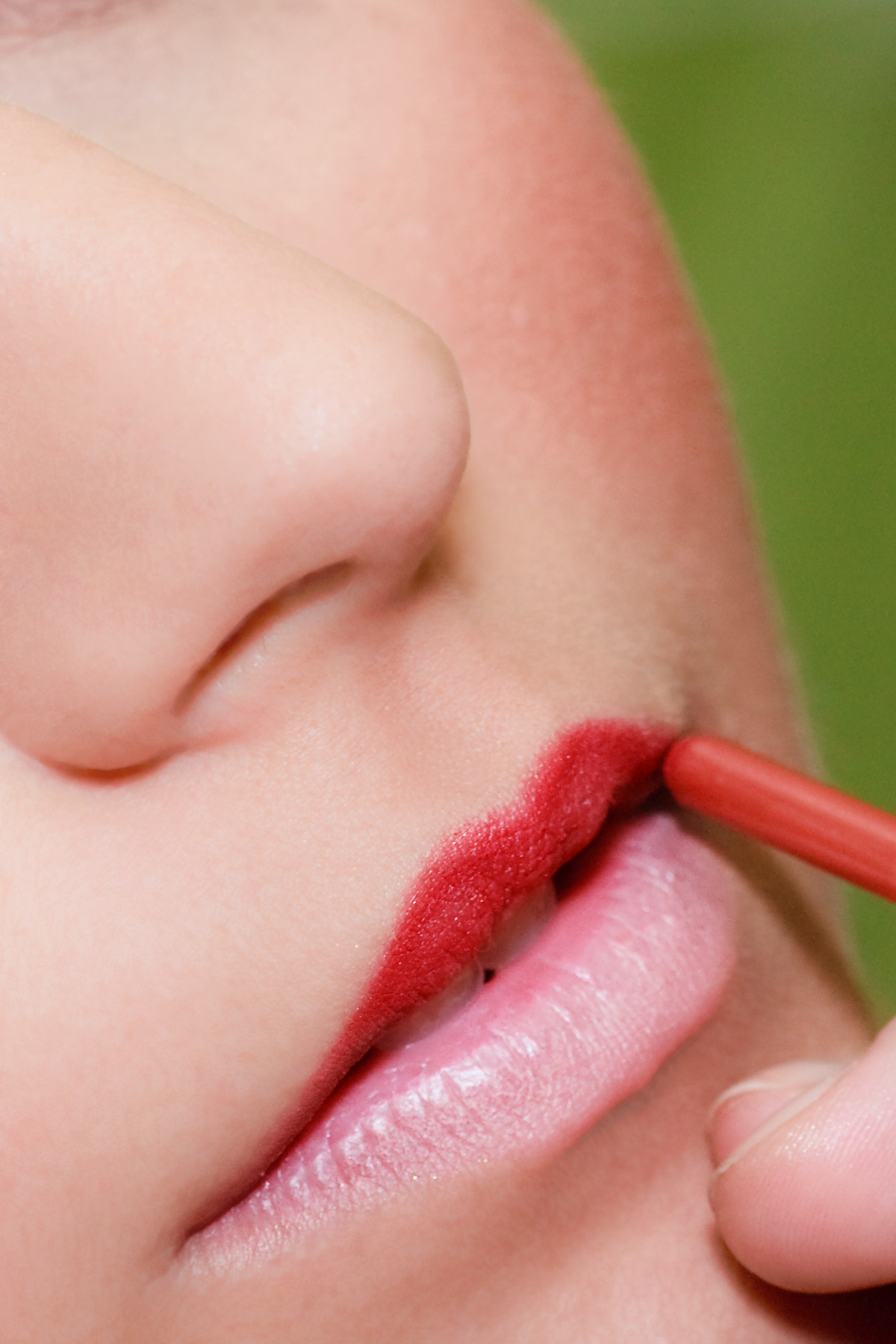 A beautiful woman applying red lipstick