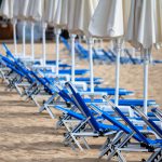 Blue beach deckchairs and umbrellas