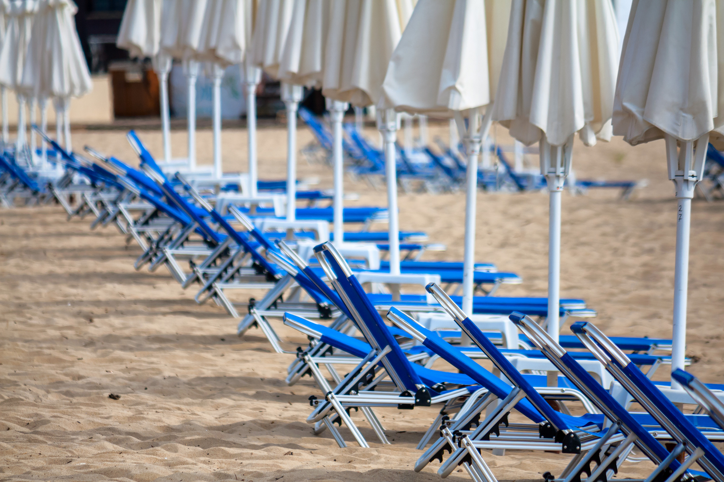 Blue beach deckchairs and umbrellas